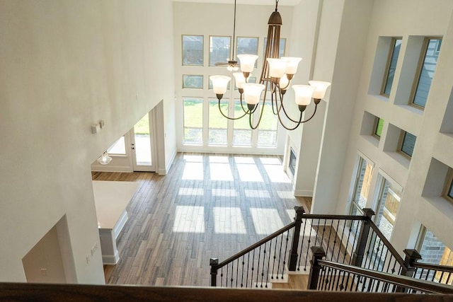 15842 Formaston Forest Dr, Humble, TX 77346 - hallway featuring a chandelier, a high ceiling, wood finished floors, baseboards, and stairs
