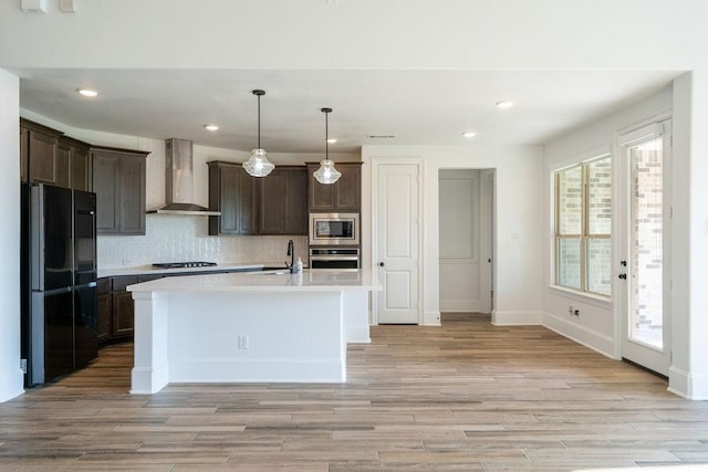 15842 Formaston Forest Dr, Humble, TX 77346 - kitchen featuring black appliances, wall chimney range hood, light countertops, dark brown cabinetry, and recessed lighting