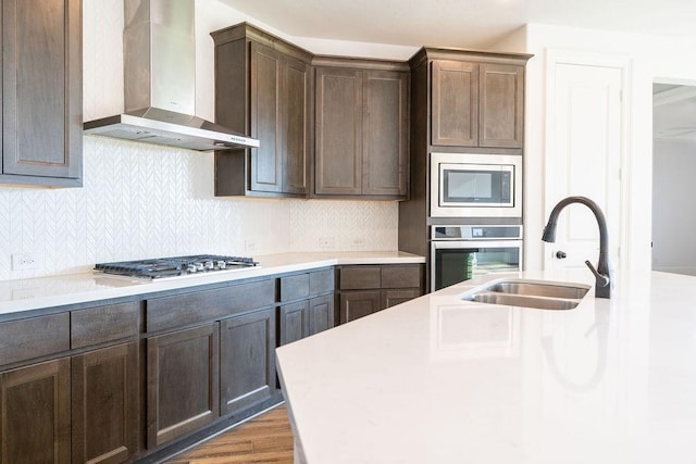 15842 Formaston Forest Dr, Humble, TX 77346 - kitchen with wall chimney range hood, appliances with stainless steel finishes, a sink, dark brown cabinetry, and light countertops