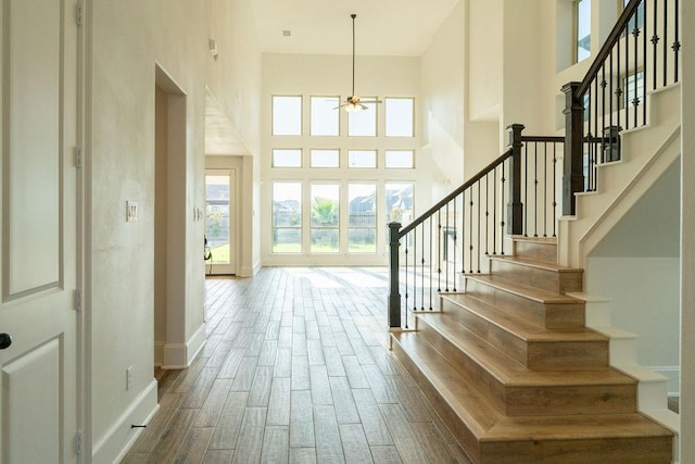 15842 Formaston Forest Dr, Humble, TX 77346 - stairway featuring a high ceiling, a ceiling fan, baseboards, and wood finished floors