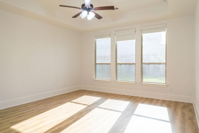 15842 Formaston Forest Dr, Humble, TX 77346 - unfurnished room with a raised ceiling, baseboards, light wood-style floors, and a ceiling fan