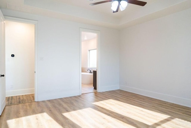15842 Formaston Forest Dr, Humble, TX 77346 - unfurnished bedroom featuring wood finished floors, baseboards, connected bathroom, and a ceiling fan