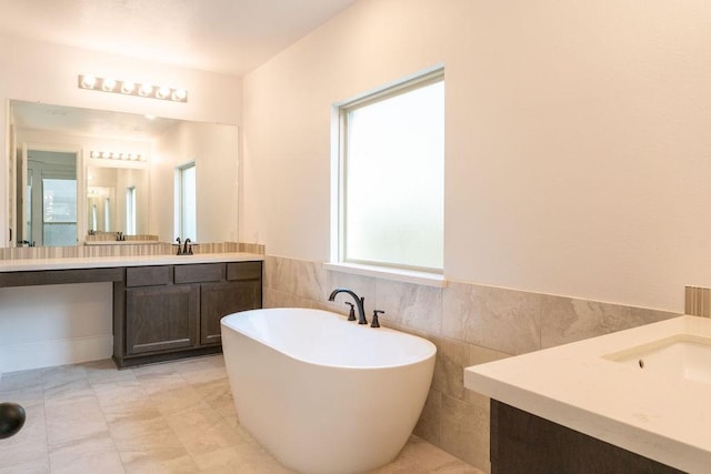 15842 Formaston Forest Dr, Humble, TX 77346 - bathroom with vanity, a freestanding bath, tile walls, and a wainscoted wall