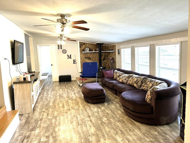 320 Deer Run Rd, Trinity, TX 75862 - living room featuring a wood stove, wood finished floors, ceiling fan, and a textured ceiling