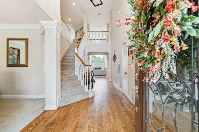 2122 Misty River Trl, Kingwood, TX 77345 - entryway with baseboards, stairway, wood finished floors, a fireplace, and ornamental molding