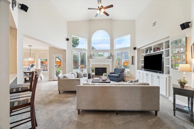 2122 Misty River Trl, Kingwood, TX 77345 - carpeted living room featuring a glass covered fireplace, high vaulted ceiling, ceiling fan, a chandelier, and baseboards