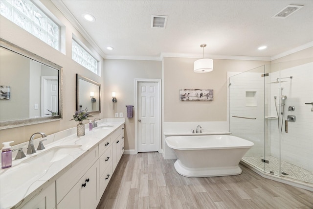2122 Misty River Trl, Kingwood, TX 77345 - full bathroom with ornamental molding, double vanity, a freestanding bath, a stall shower, and recessed lighting