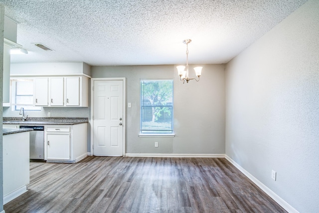 828 Noreda St, Angleton, TX 77515 - kitchen with dishwasher, wood finished floors, a textured ceiling, and white cabinets