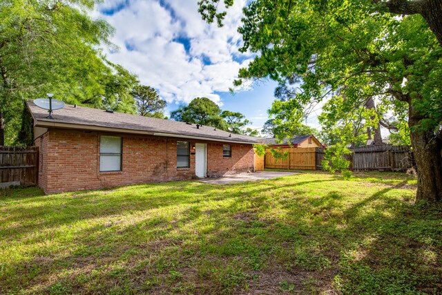 828 Noreda St, Angleton, TX 77515 - back of property with a patio and brick siding