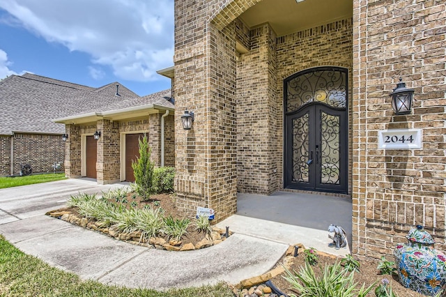 2044 Doolan Dr, Conroe, TX 77301 - doorway to property with brick siding, driveway, a garage, and a shingled roof