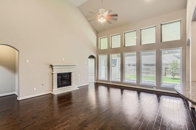 2044 Doolan Dr, Conroe, TX 77301 - unfurnished living room with high vaulted ceiling, arched walkways, a ceiling fan, and dark wood finished floors