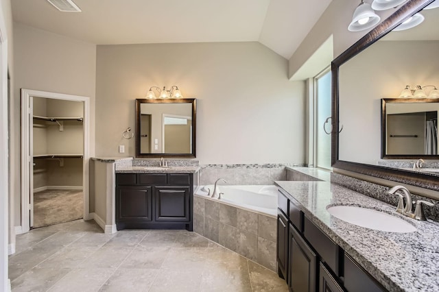 2044 Doolan Dr, Conroe, TX 77301 - full bath featuring lofted ceiling, a bath, two vanities, and tile patterned flooring