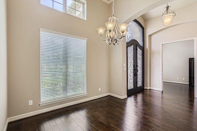 2044 Doolan Dr, Conroe, TX 77301 - empty room with a chandelier, arched walkways, plenty of natural light, and dark wood-style floors