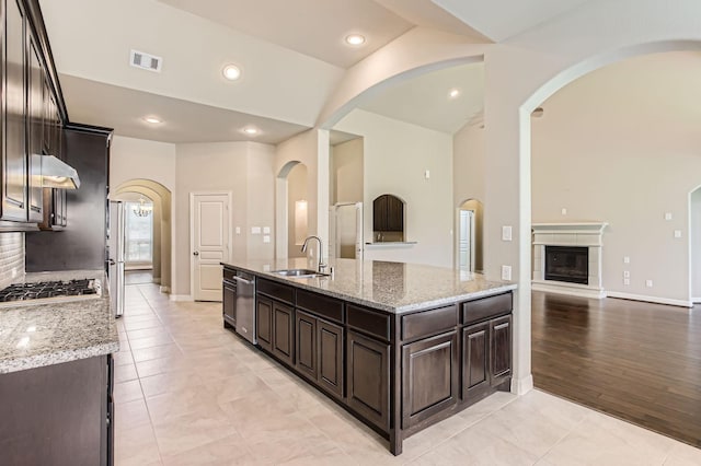 2044 Doolan Dr, Conroe, TX 77301 - kitchen featuring a sink, stainless steel appliances, dark brown cabinetry, arched walkways, and recessed lighting