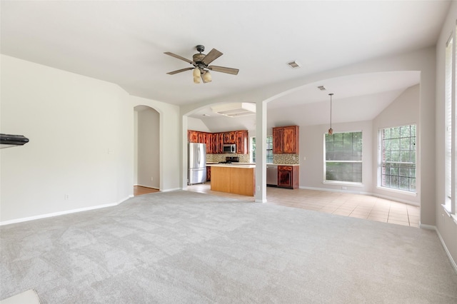 2606 Spring Chase Dr, Spring, TX 77386 - unfurnished living room with ceiling fan, light colored carpet, vaulted ceiling, arched walkways, and baseboards