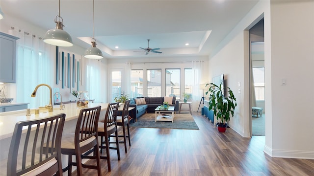 2002 Village Orchard Ln, Katy, TX 77423 - dining room featuring a raised ceiling, a ceiling fan, dark wood-style flooring, baseboards, and recessed lighting