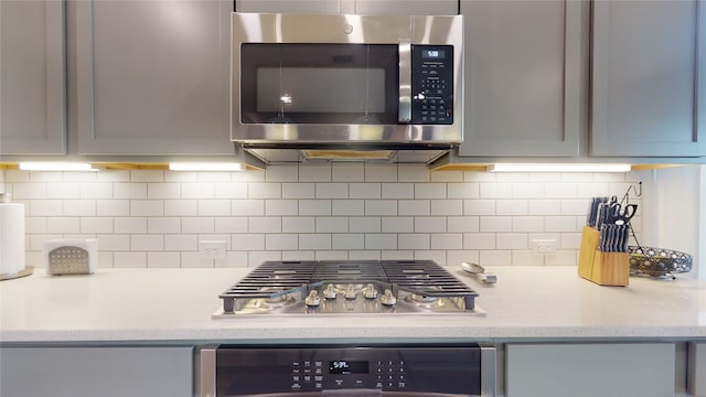 2002 Village Orchard Ln, Katy, TX 77423 - kitchen featuring stainless steel appliances, decorative backsplash, and gray cabinets