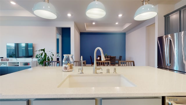 2002 Village Orchard Ln, Katy, TX 77423 - kitchen with freestanding refrigerator, a sink, open floor plan, a raised ceiling, and light stone counters