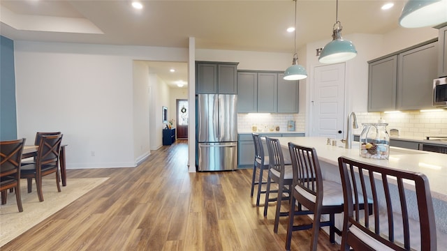 2002 Village Orchard Ln, Katy, TX 77423 - kitchen featuring stainless steel appliances, gray cabinetry, light countertops, wood finished floors, and recessed lighting