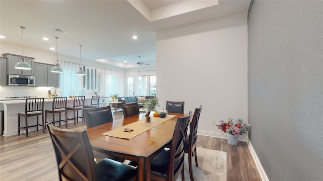 2002 Village Orchard Ln, Katy, TX 77423 - dining area with a raised ceiling, light wood finished floors, recessed lighting, baseboards, and a ceiling fan