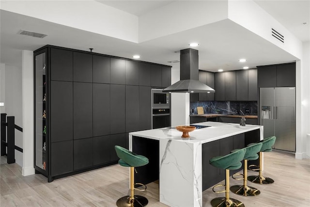 5555 Del Monte Dr Unit 103, Houston, TX 77056 - kitchen featuring island exhaust hood, black appliances, a breakfast bar area, modern cabinets, and a center island