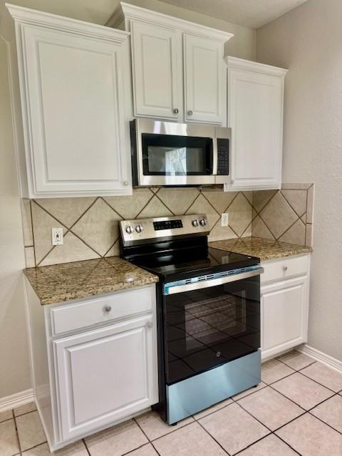 1119 Autumn Green Dr, Missouri City, TX 77459 - kitchen with appliances with stainless steel finishes, tasteful backsplash, white cabinetry, and baseboards