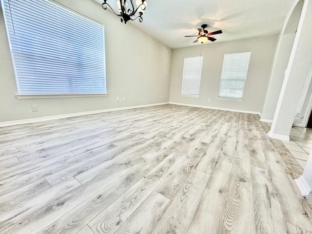 1119 Autumn Green Dr, Missouri City, TX 77459 - empty room featuring ceiling fan, light wood-type flooring, a chandelier, and baseboards