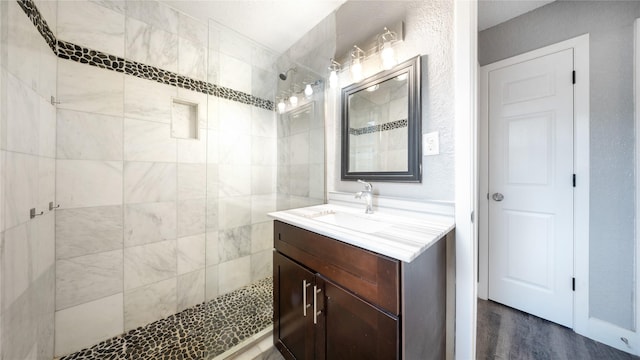 306 W Wilkins St, League City, TX 77573 - bathroom with a tile shower, vanity, and wood finished floors