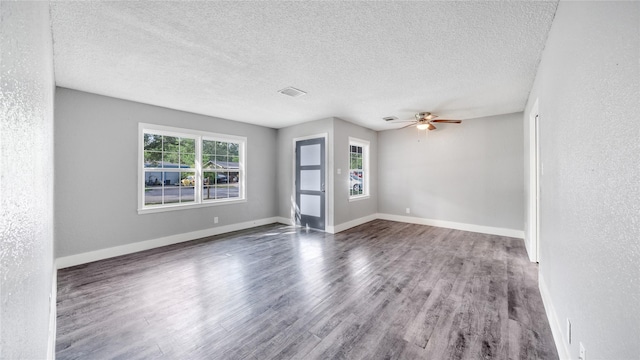 306 W Wilkins St, League City, TX 77573 - spare room featuring wood finished floors, a textured ceiling, a ceiling fan, baseboards, and a textured wall