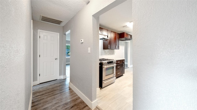 306 W Wilkins St, League City, TX 77573 - hallway featuring a textured wall, light wood finished floors, baseboards, and a textured ceiling