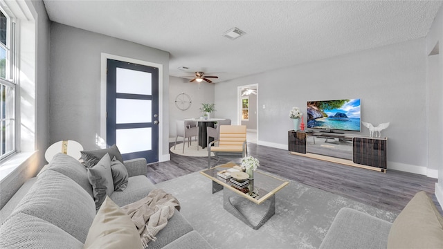 306 W Wilkins St, League City, TX 77573 - living room featuring wood finished floors, ceiling fan, baseboards, and a textured ceiling
