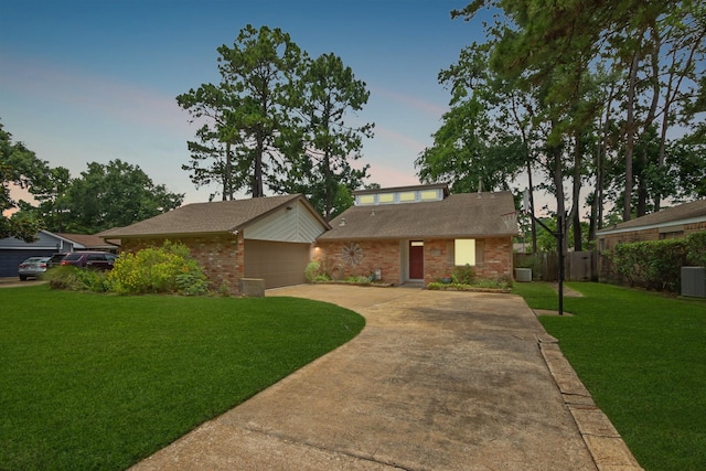14922 Sandy Creek Dr, Houston, TX 77070 - mid-century home with a garage, driveway, central AC unit, brick siding, and roof with shingles