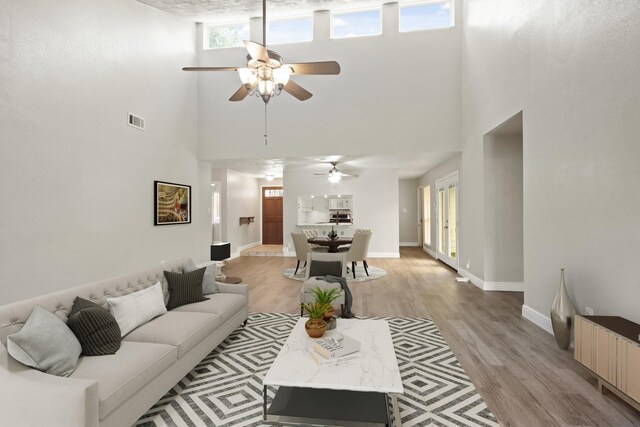 14922 Sandy Creek Dr, Houston, TX 77070 - living room featuring a towering ceiling, ceiling fan, light wood finished floors, radiator heating unit, and baseboards