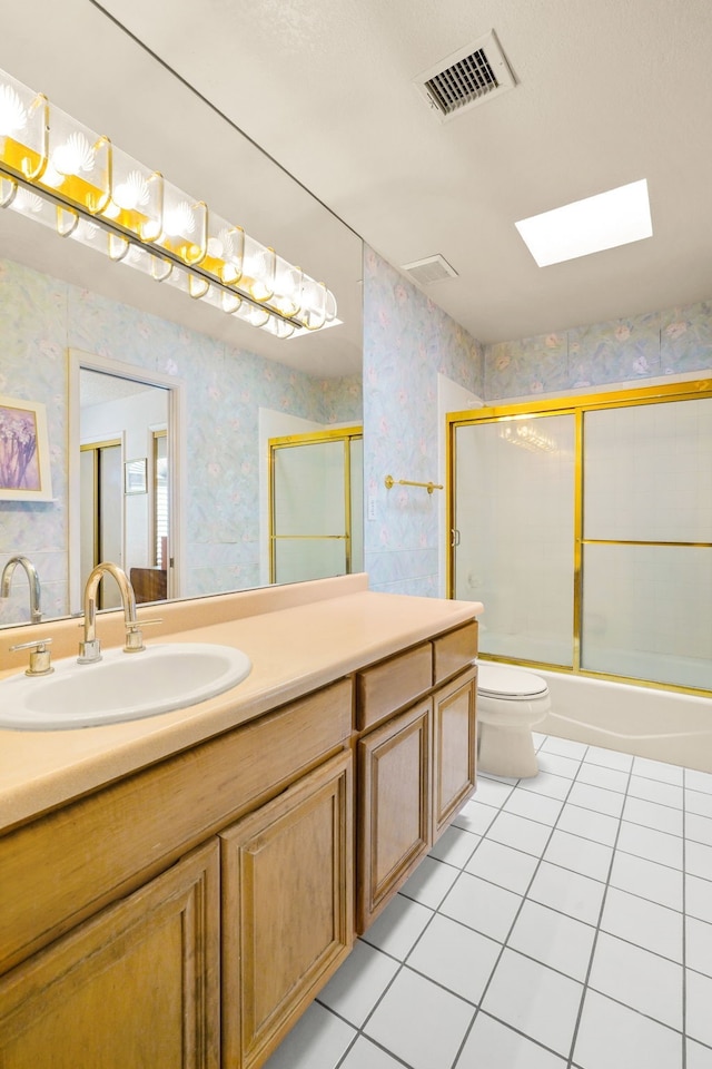 6574 Eagle Ridge Dr, El Paso, TX 79912 - full bathroom featuring wallpapered walls, tile patterned floors, toilet, vanity, and enclosed tub / shower combo