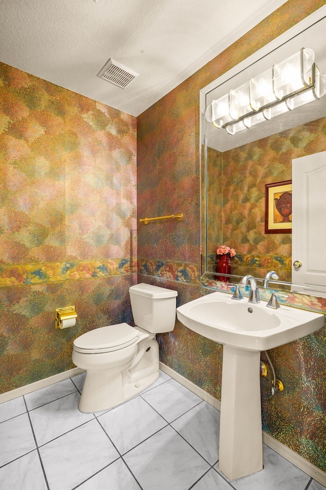 6574 Eagle Ridge Dr, El Paso, TX 79912 - half bath with baseboards, toilet, wallpapered walls, a sink, and marble finish floors