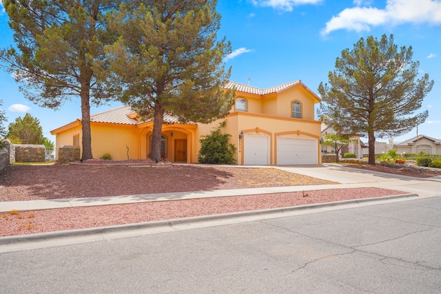6574 Eagle Ridge Dr, El Paso, TX 79912 - mediterranean / spanish home featuring a garage, stucco siding, concrete driveway, and a tile roof