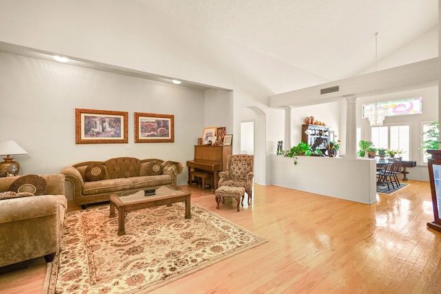 6574 Eagle Ridge Dr, El Paso, TX 79912 - living area featuring light wood-style flooring, high vaulted ceiling, and decorative columns