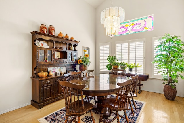 6574 Eagle Ridge Dr, El Paso, TX 79912 - dining space featuring light wood finished floors, a chandelier, high vaulted ceiling, and baseboards
