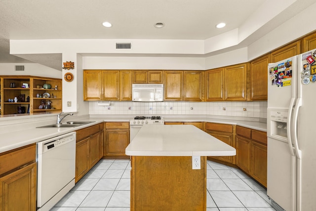 6574 Eagle Ridge Dr, El Paso, TX 79912 - kitchen with white appliances, a sink, brown cabinets, light countertops, and a center island