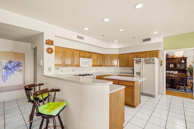 6574 Eagle Ridge Dr, El Paso, TX 79912 - kitchen featuring white appliances, light tile patterned flooring, light countertops, a peninsula, and recessed lighting