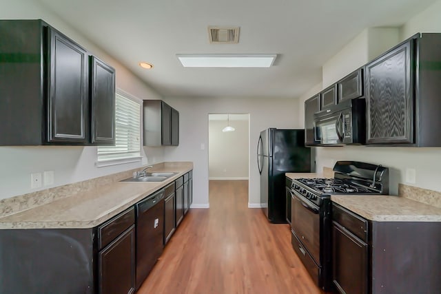 722 Horseshoe Springs Ln, Houston, TX 77090 - kitchen with black appliances, a sink, light wood-type flooring, and light countertops