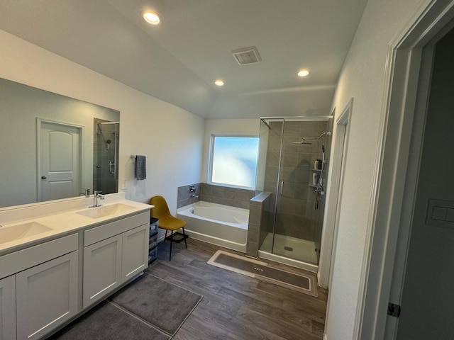 10026 Rose Mallow Ln, Magnolia, TX 77354 - bathroom featuring wood finished floors, a shower stall, a garden tub, vaulted ceiling, and double vanity