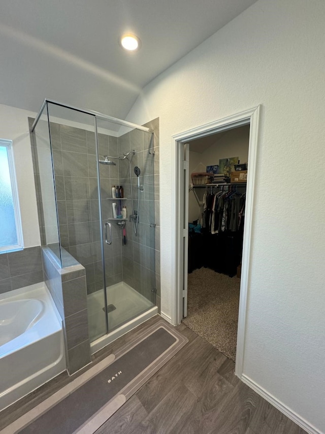 10026 Rose Mallow Ln, Magnolia, TX 77354 - bathroom with a bath, a shower stall, a walk in closet, wood finished floors, and vaulted ceiling