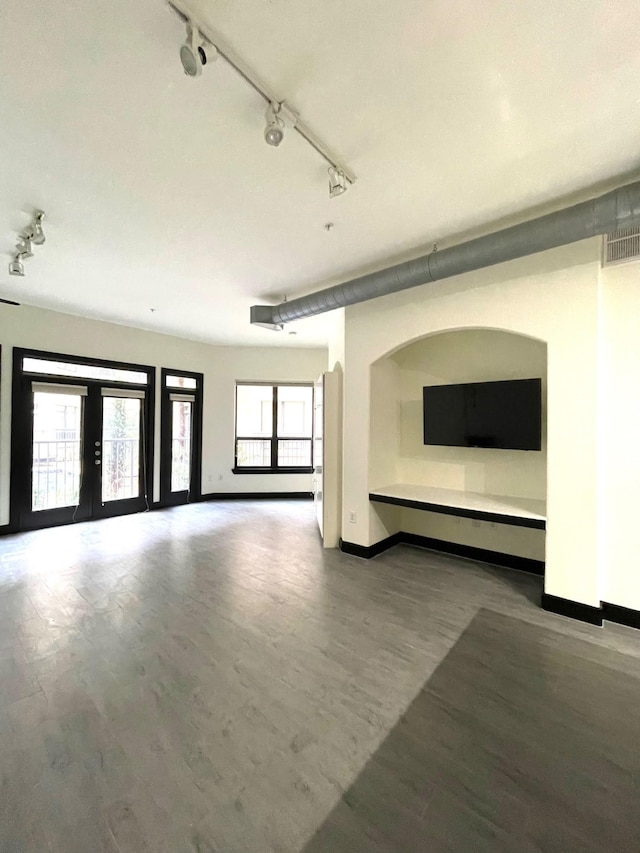 1901 Post Oak Blvd Unit 1213, Houston, TX 77056 - unfurnished living room with track lighting, baseboards, and wood finished floors