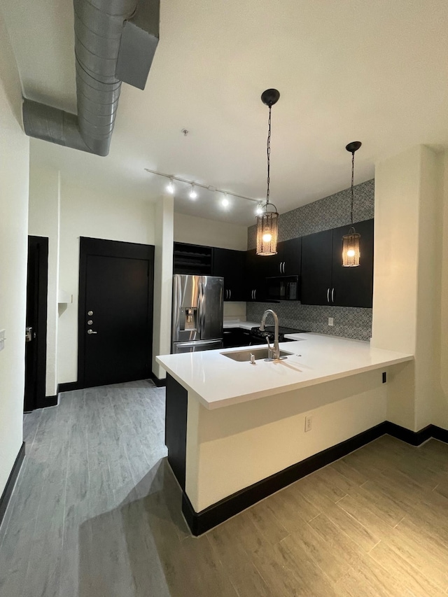 1901 Post Oak Blvd Unit 1213, Houston, TX 77056 - kitchen with stainless steel fridge, dark cabinetry, light wood-style flooring, and light countertops