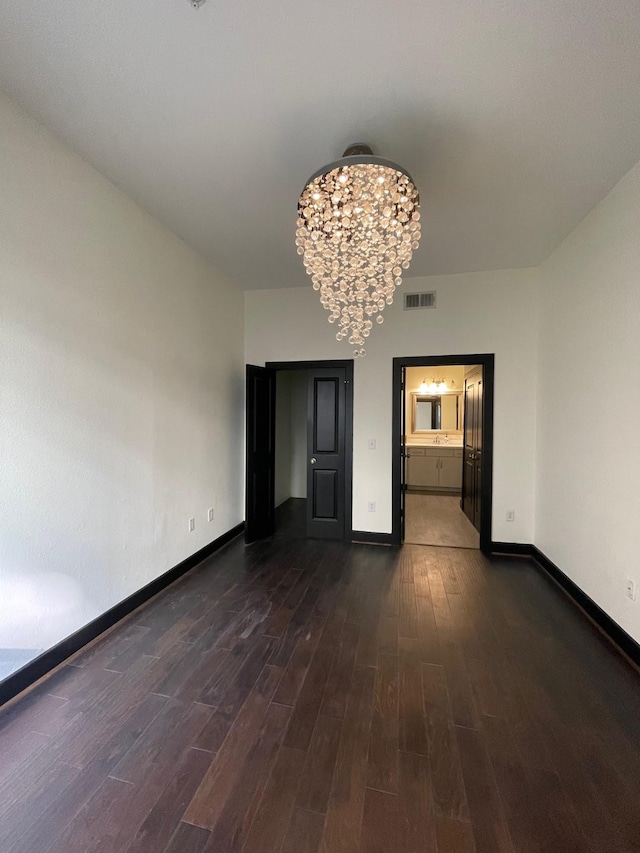 1901 Post Oak Blvd Unit 1213, Houston, TX 77056 - unfurnished room featuring dark wood finished floors, a chandelier, and baseboards