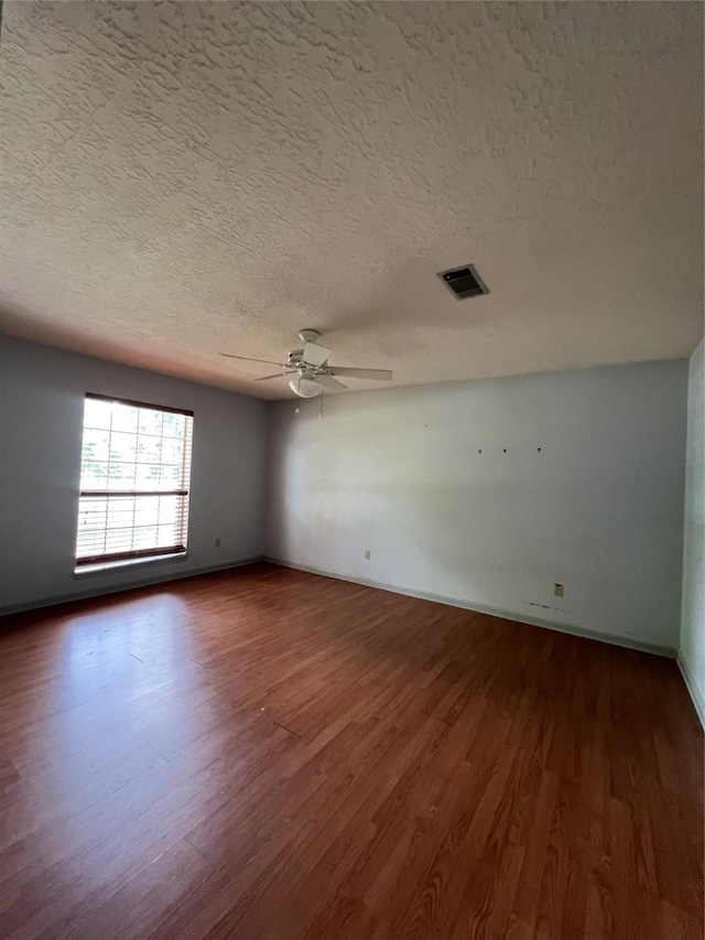 101 Willowbend St, Huntsville, TX 77320 - unfurnished room featuring dark wood finished floors, a ceiling fan, a textured ceiling, and baseboards