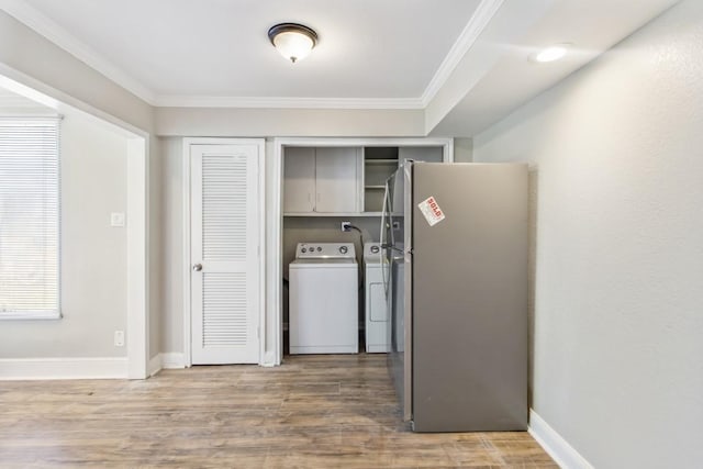208 Preston St, La Marque, TX 77568 - laundry room featuring cabinet space, ornamental molding, washer and dryer, wood finished floors, and baseboards