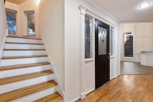 17902 Fernbluff Dr, Spring, TX 77379 - foyer featuring stairway, light wood-style floors, ornamental molding, a textured ceiling, and recessed lighting