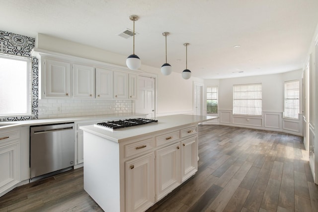 17902 Fernbluff Dr, Spring, TX 77379 - kitchen with stainless steel appliances, dark wood-style flooring, light countertops, wainscoting, and a kitchen island